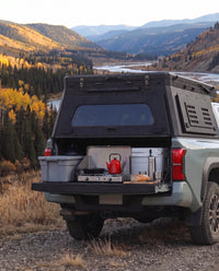 Tailgate camp kitchen under the rear hatch of a Toyota Tacoma truck bed camper