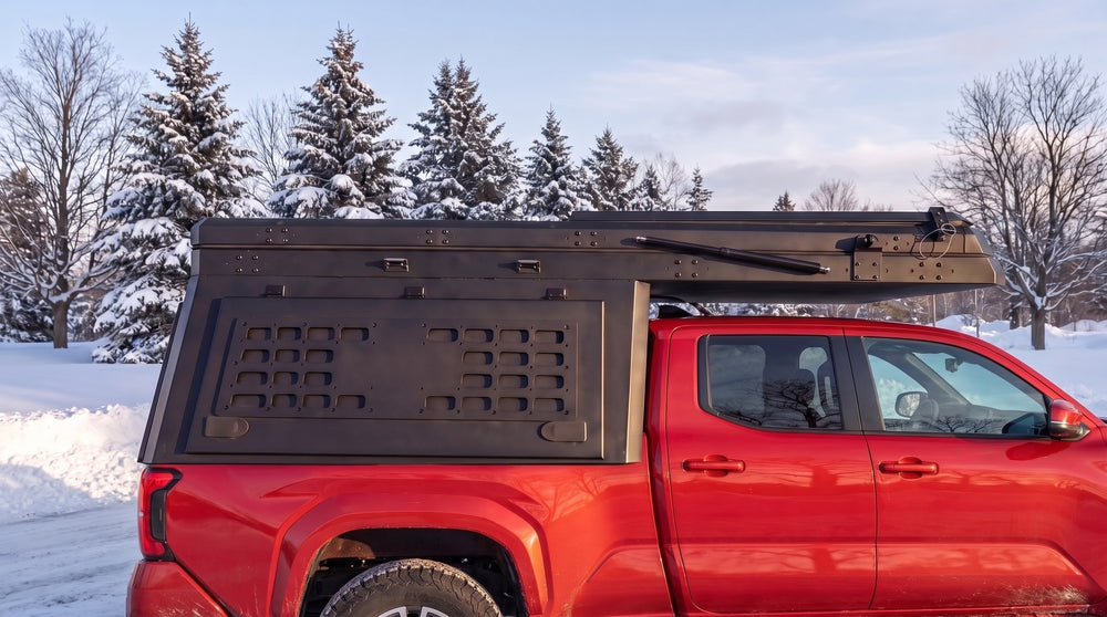 Toyota Tacoma truck cap camper closed up for winter driving on a snowy Ontario road