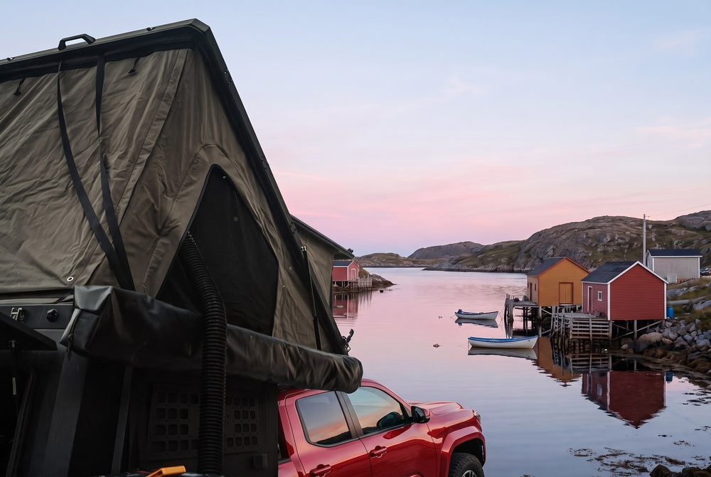 Side of the open roof tent on a Toyota Tacoma, overlooking a Newfoundland fishing cove at dawn (the side awning shown is not included)