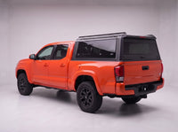 Toyota Tacoma truck cap with the honeycomb security guard showing through the tinted rear window, studio view
