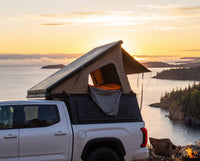 Toyota Tundra pop-up truck cap camper with the roof tent open at sunset over Lake Superior