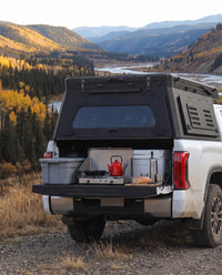 Tailgate camp kitchen under the rear hatch of a Toyota Tundra truck bed camper