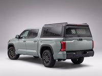 Toyota Tundra truck cap with the honeycomb security guard showing through the tinted rear window, studio view