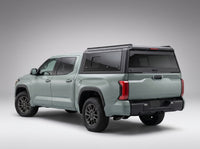 Matte black aluminum truck cap with tinted windows on a Toyota Tundra, studio rear three-quarter view