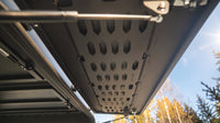Underside of the raised side hatch showing the laser-cut MOLLE panel and gas struts