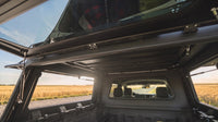 Inside the aluminium truck cap looking forward, with the pass-through up into the pop-up roof tent