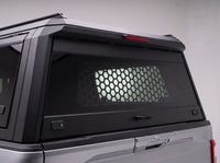 Honeycomb security window guard behind the tinted rear glass of the TruckTon aluminum truck cap