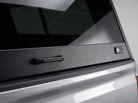 Close-up of the rear door pull handle and corner latch on the aluminum truck cap