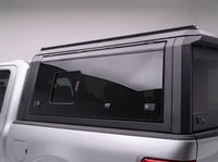Close-up of the vent window and two latches on the truck cap's tinted side window
